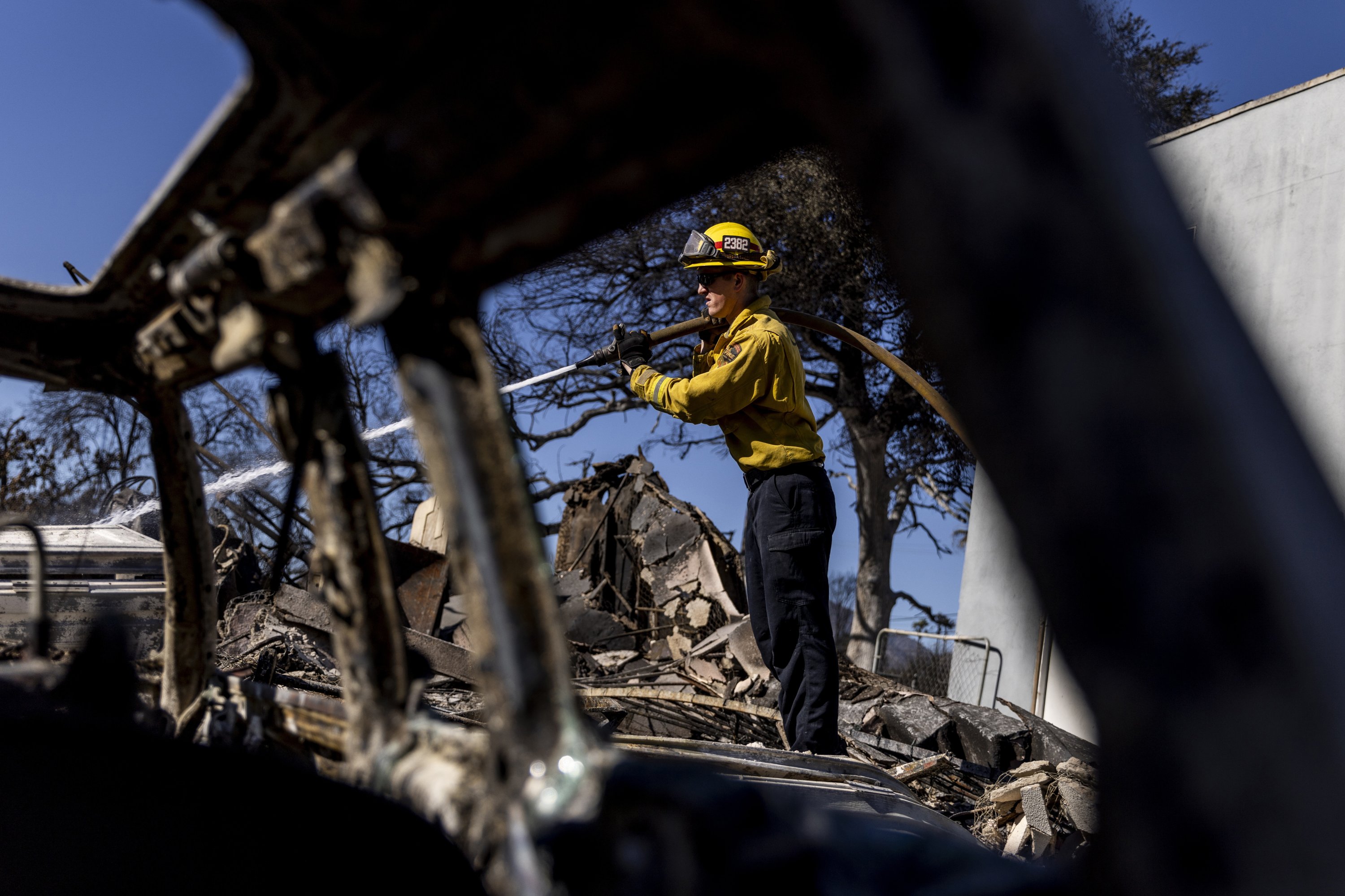 A firefighter hoses down a hotspot at a home destroyed by the Eaton Fire in Altadena, California, U.S., Jan. 12, 2025. (AP Photo)