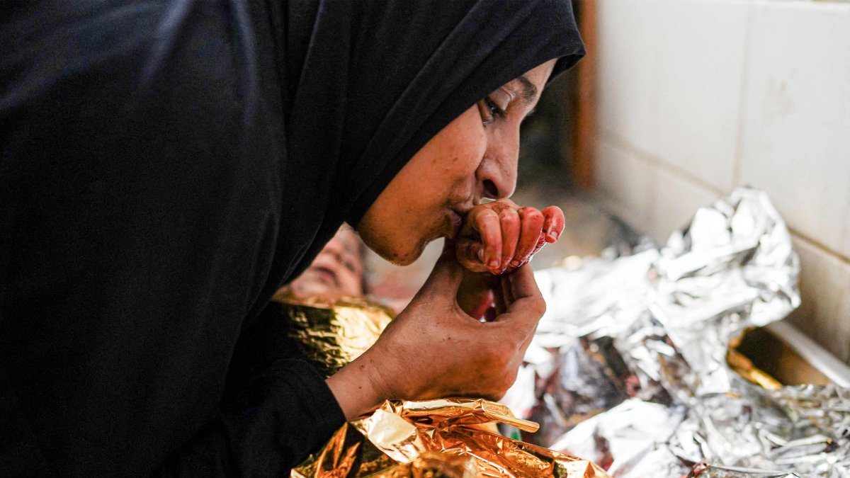 A mother bids farewell to the body of her child who was killed in the aftermath of overnight Israeli bombardment in al-Maghazi in the central Gaza Strip, at the morgue of the Aqsa Martyrs Hospital in Deir el-Balah, June 25, 2024. (AFP Photo)