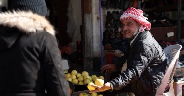 A fruit vendor speaks to a customer in Homs, Syria, Jan. 8, 2025. (AFP Photo)