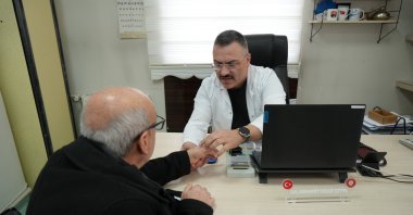 A doctor examining a patient's hand in Erzincan, Türkiye, Jan. 14, 2025. (IHA Photo)