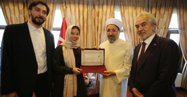 Rena Saito receives her conversion certificate from the mufti, Istanbul, Türkiye. (AA Photo)