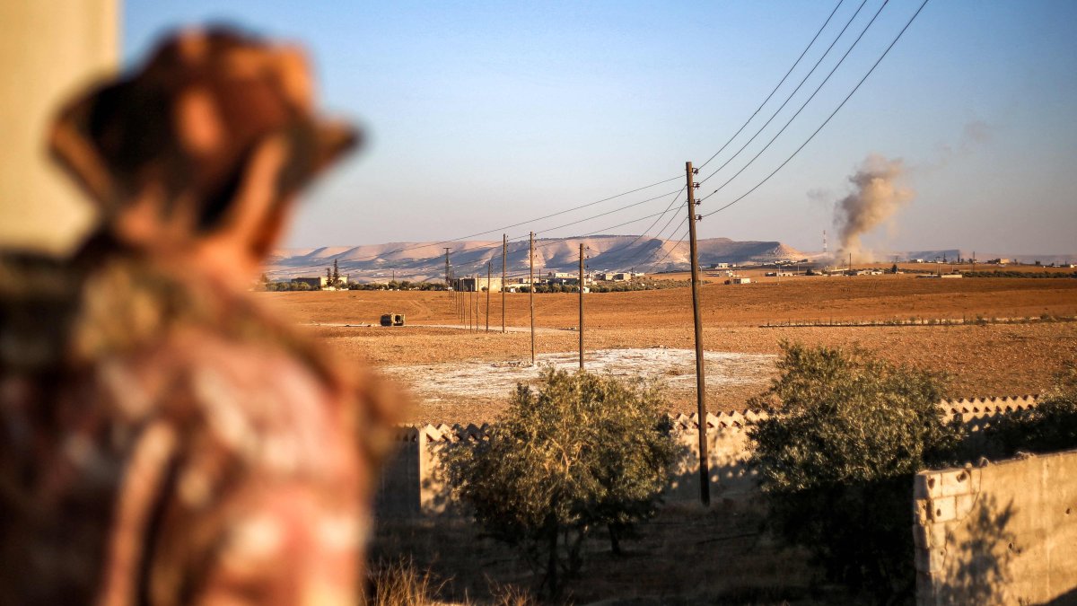 A fighter of the Syrian National Army (SNA) watches a plume of smoke erupt from bombardment at a position near the Tishrin Dam amid clashes with the PKK/YPG terrorists in Manbij, northern Aleppo province, Syria, Jan. 10, 2025. (AFP Photo)