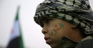A child with writing on his face in the Syrian flag's colors reading "Revolution" takes part in a "Liberation Festival" to celebrate the ouster of Syrian regime leader Bashar Assad, Idlib, northwestern Syria, Dec. 22, 2024. (EPA Photo)