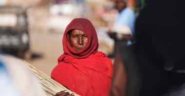 A woman walks on the dusty roads of the marketplace in the town of Haiya, Red Sea State, eastern Sudan, Dec. 25, 2024. (AA Photo)