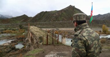 An Azerbaijani service member looks at the ancient Khodaafarin Bridge near the border with Iran in the area in Jabrayil District, Karabakh, Azerbaijan, Dec. 7, 2020. (Reuters File Photo)
