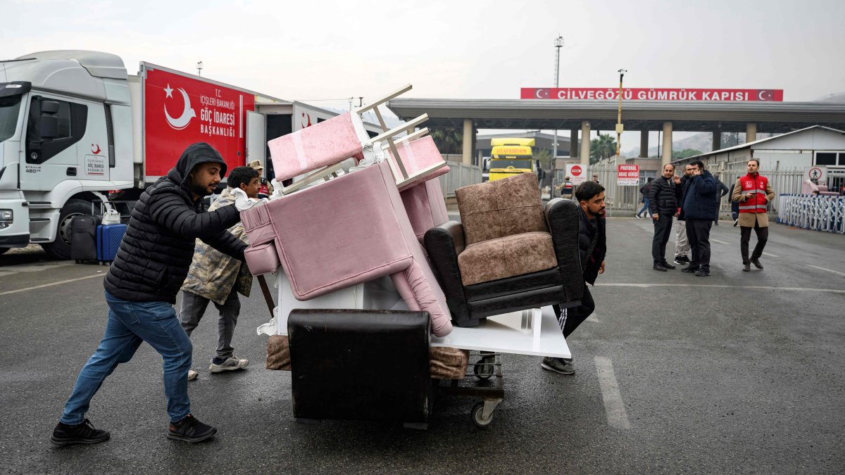 Syrians living in Türkiye push a cart loaded with their furniture at the Cilvegözü, in Reyhanli, Türkiye, Dec. 12, 2024. (AFP Photo)