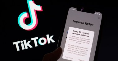 This illustration photo shows the TikTok app on a smartphone screen in front of the TikTok logo in Los Angeles, U.S., Jan. 18, 2025. (AFP Photo)