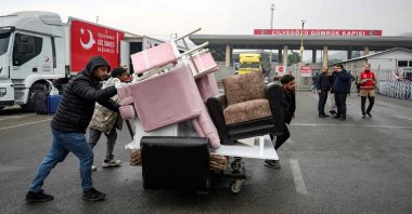 Syrians living in Türkiye push a cart loaded with their furniture at the Cilvegözü, in Reyhanli, Türkiye, Dec. 12, 2024. (AFP Photo)