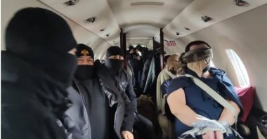 This undated photo shared by the Interior Ministry shows the suspects being escorted by Turkish officers aboard a plane. (Courtesy of the Interior Ministry)