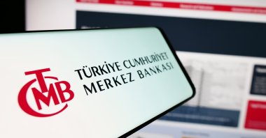 In this photo illustration, a mobile phone with the logo of the Central Bank of the Republic of Türkiye (CBRT) is seen in front of the website, Germany, June 24, 2024. (Reuters Photo)