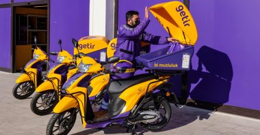 An employee of the Turkish fast grocery-delivery company Getir prepares to deliver an online grocery delivery in front of a store warehouse, Istanbul, Türkiye, Nov. 12, 2021. (Reuters Photo)