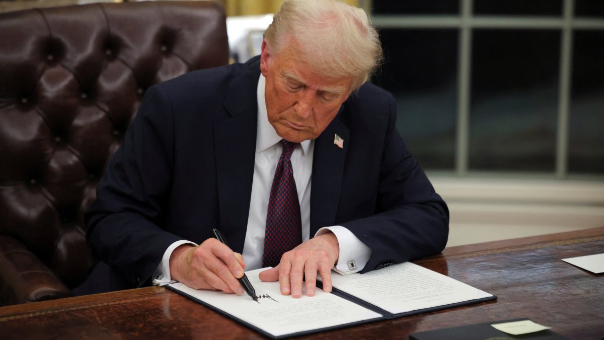 U.S. President Donald Trump signs documents as he issues executive orders and pardons for Jan. 6 defendants in the Oval Office at the White House, Washington, D.C., U.S., Jan. 20, 2025.  (Reuters Photo)
