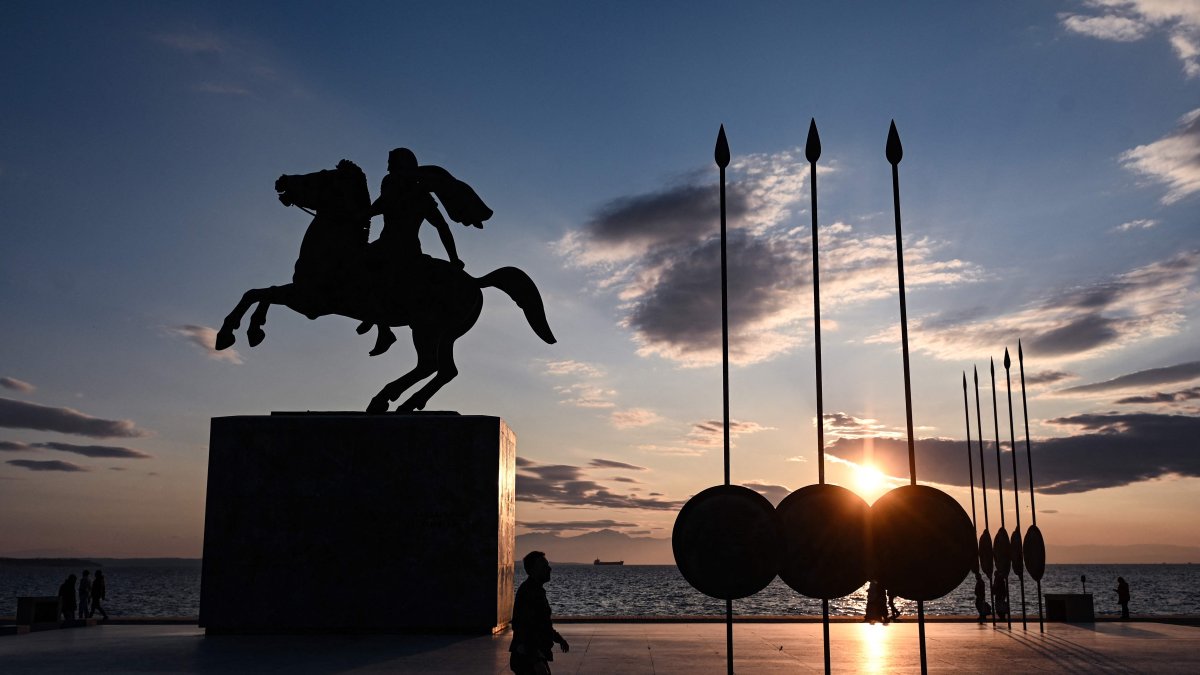 People walk next to the statue of Alexander the Great at sunset in the northern Greek city of Thessaloniki, on Dec. 28, 2024. (AFP File Photo)