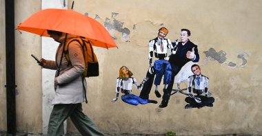 A man walks past a mural by Italian artist Harry Greb depicting Elon Musk as a puppeteer and Donald Trump, Giorgia Meloni and Emmanuel Macron as his puppets, Rome, Italy, Jan. 20, 2025. (EPA Photo)
