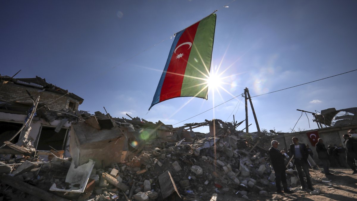 Azerbaijan&#039;s national flag flies over destroyed houses in a residential area that was hit by rocket fire from Armenian forces during the First Karabakh War, Ganja, Azerbaijan, Oct. 22, 2020. (AP Photo)