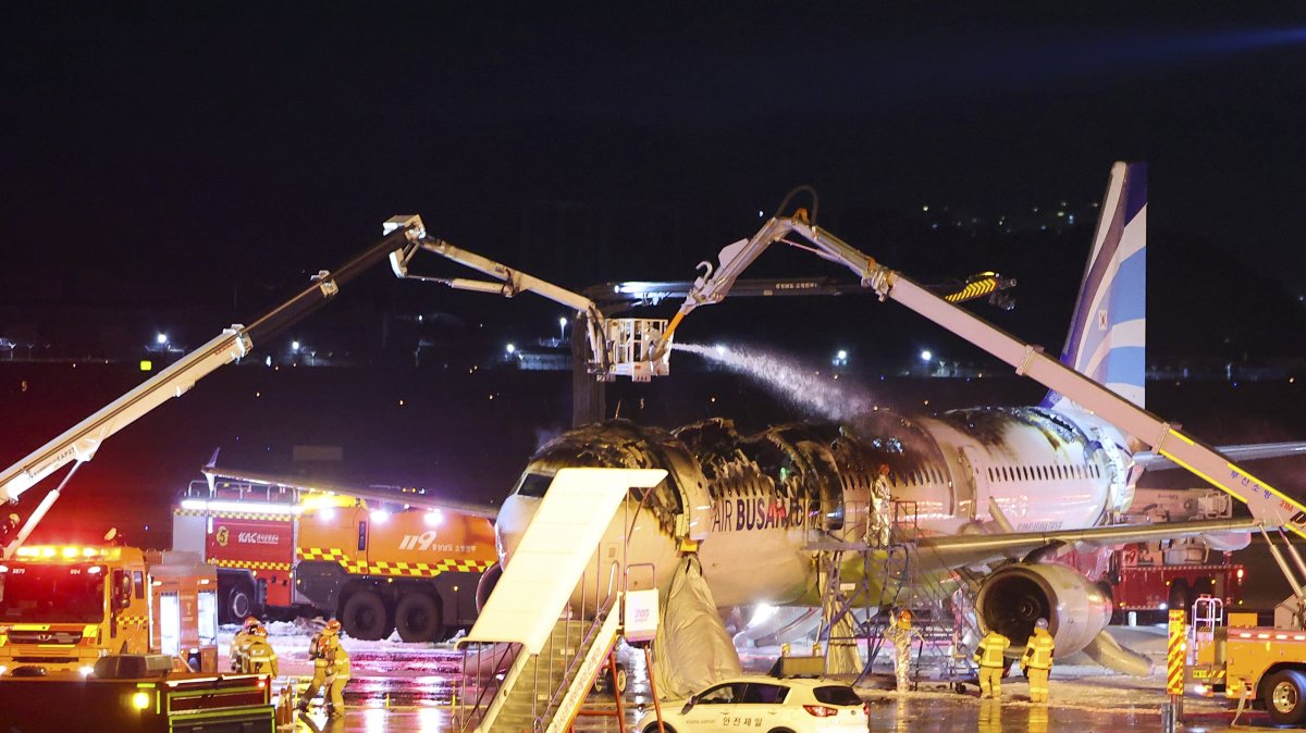 Firefighters work to extinguish a fire on an Air Busan airplane at Gimhae International Airport in Busan, South Korea, Jan. 28, 2025. (AP Photo)