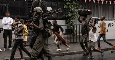 A member of the M23 armed group walks alongside residents through a street of the Keshero neighborhood in Goma, DR Congor, Jan. 27, 2025. (AFP Photo)