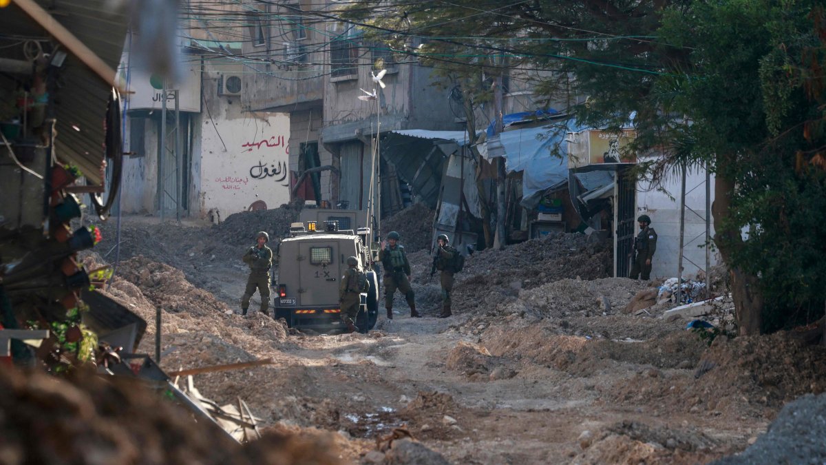 Israeli soldiers stand near their vehicle on a destroyed road as they conduct a raid in Tulkarem in the Israel-occupied West Bank, Palestine, Jan. 28, 2025. (AFP Photo)