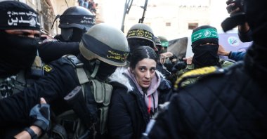 Palestinian resistance group members escort Arbel Yehud to hand her over to a Red Cross team Khan Yunis, southern Gaza, Jan. 30, 2025. (AFP Photo)