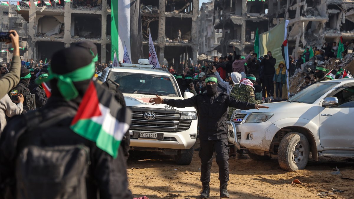Vehicles belonging to the International Committee of the Red Cross (ICRC) drive near members of the Al-Qassam Brigades before the release of an Israeli, Jabaliya refugee camp, northern Gaza Strip, Palestine, Jan. 30, 2025. (EPA Photo)