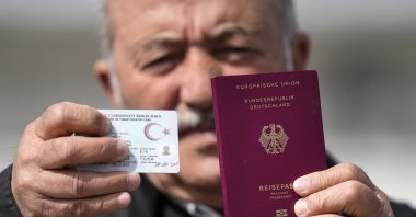 Mehmet Ali Yiğit, who has been living in Germany for more than 50 years, shows his German passport and Turkish ID after he voted at the Gruga Hall, Essen, Germany, April 27, 2023. (AP Photo)