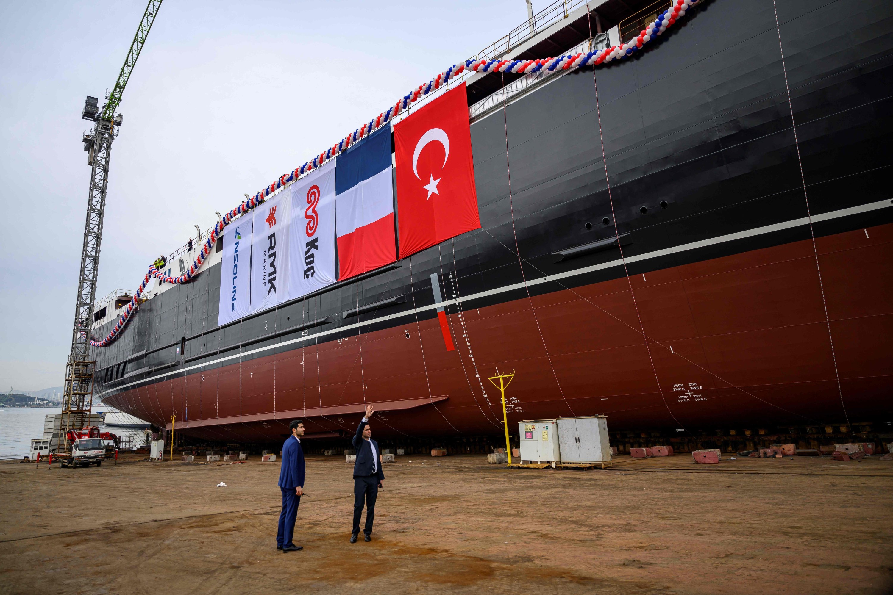 Workers walk past the world's longest wind-powered cargo ship Neoliner Origin during its launching ceremony at the port of Tuzla, outside Istanbul, Türkiye, Jan. 30, 2025. (AFP Photo)
