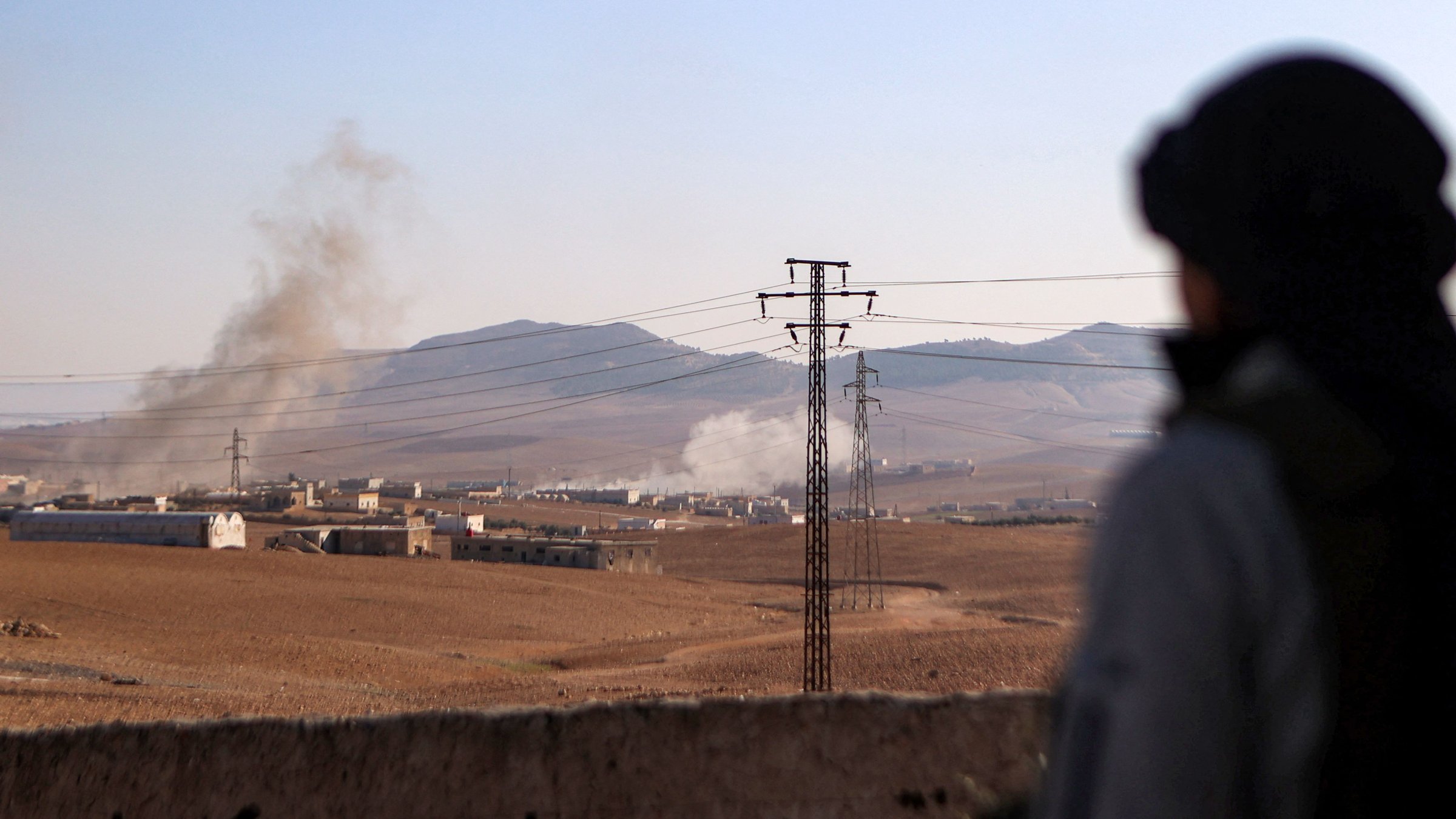 A Syrian National Army (SNA) fighter watches a plume of smoke erupt from bombardment at a position near the Tishrin Dam in the vicinity of Manbij, Syria, Jan. 10, 2025. (AFP Photo)