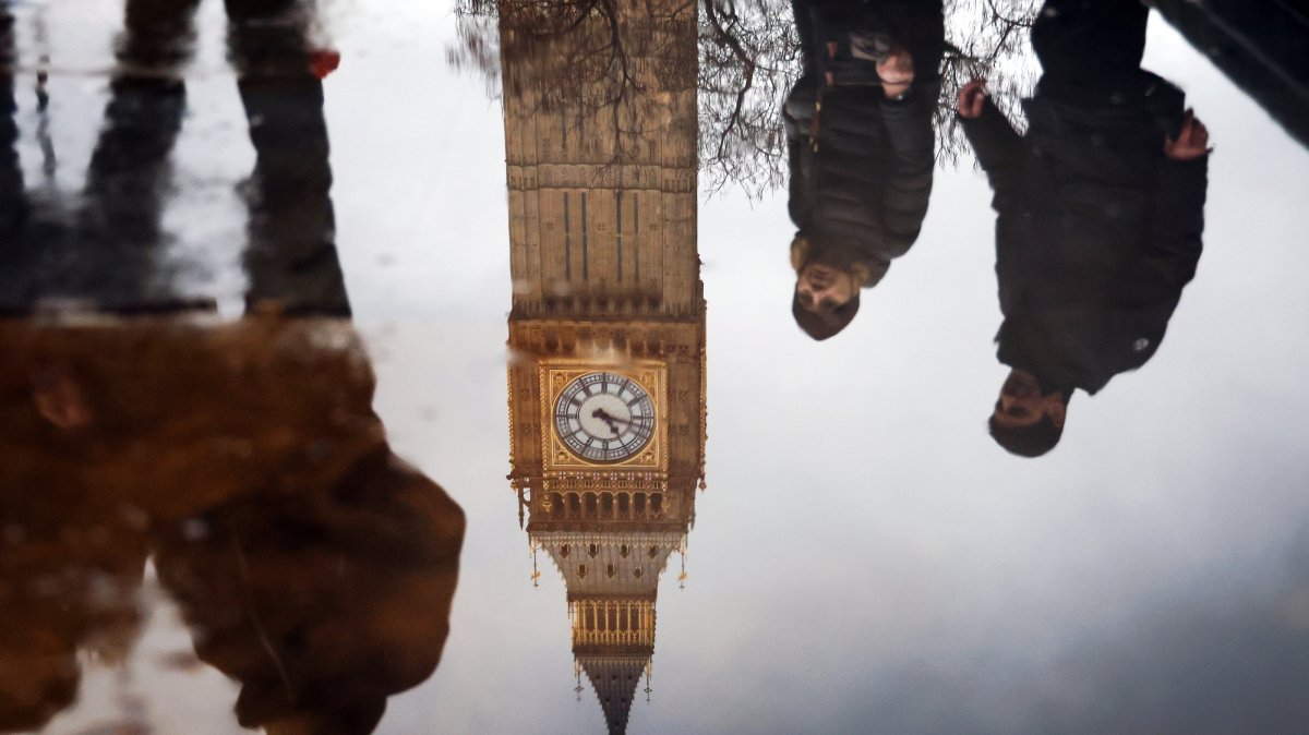 Pedestrians and the face of the Elizabeth Tower are reflected in a puddle outside the British Parliament London, U.K., Jan. 31, 2025. (EPA Photo)