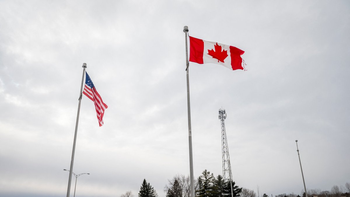 The Canadian and U.S. flags fly near the Canada-U.S. border in Blackpool, Quebec, Canada, Feb. 2, 2025. (AFP Photo)