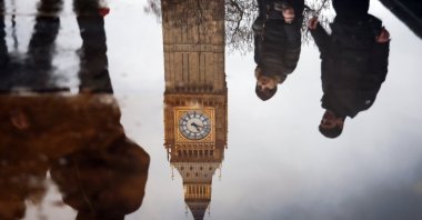 Pedestrians and the face of the Elizabeth Tower are reflected in a puddle outside the British Parliament London, U.K., Jan. 31, 2025. (EPA Photo)