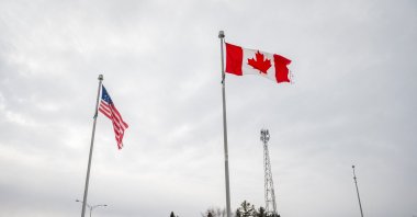 The Canadian and U.S. flags fly near the Canada-U.S. border in Blackpool, Quebec, Canada, Feb. 2, 2025. (AFP Photo)