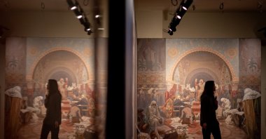 A visitor looks at artworks by Czech artist Alphonse Mucha displayed during a press preview of the new Mucha Museum in Prague, Czechia, Jan. 3, 2025. (EPA Photo)