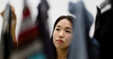 In this photograph, South Korean climate activist Lee So-yeon, who has not bought any new clothes for the past six years, looks at a selection of her clothes, during an interview, Seoul, South Korea, July 23, 2024. (AFP Photo)