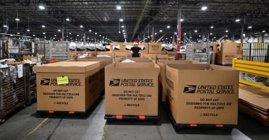 A U.S. Postal Service employee wearing a Santa hat sorts mail at the Los Angeles Processing and Distribution Center, Los Angeles, U.S., Nov. 30, 2022. (AFP Photo)