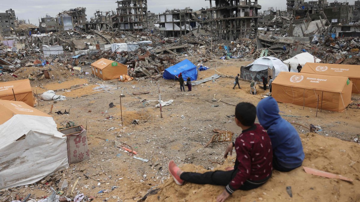 Displaced Palestinian children sit on a sand mound overlooking tents set up amid destroyed buildings in Jabalia in the northern Gaza Strip, Palestine, Feb. 5, 2025. (AFP Photo)