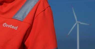 The logo for Orsted can be seen on the jacket worn by an employee close to an offshore wind farm near Nysted, Denmark, Sept. 4, 2023. (Reuters Photo)