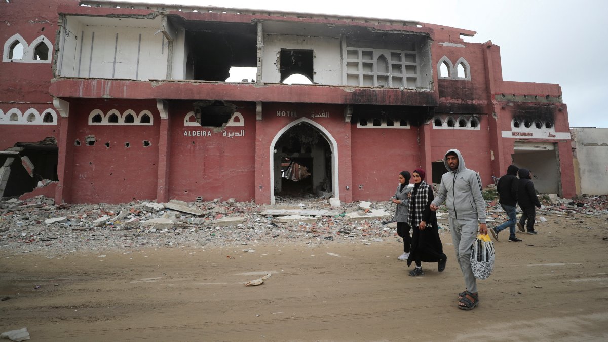 Palestinians walk past the damaged Aldeira hotel, Gaza City, Palestine, Feb. 6, 2025. (Reuters Photo)
