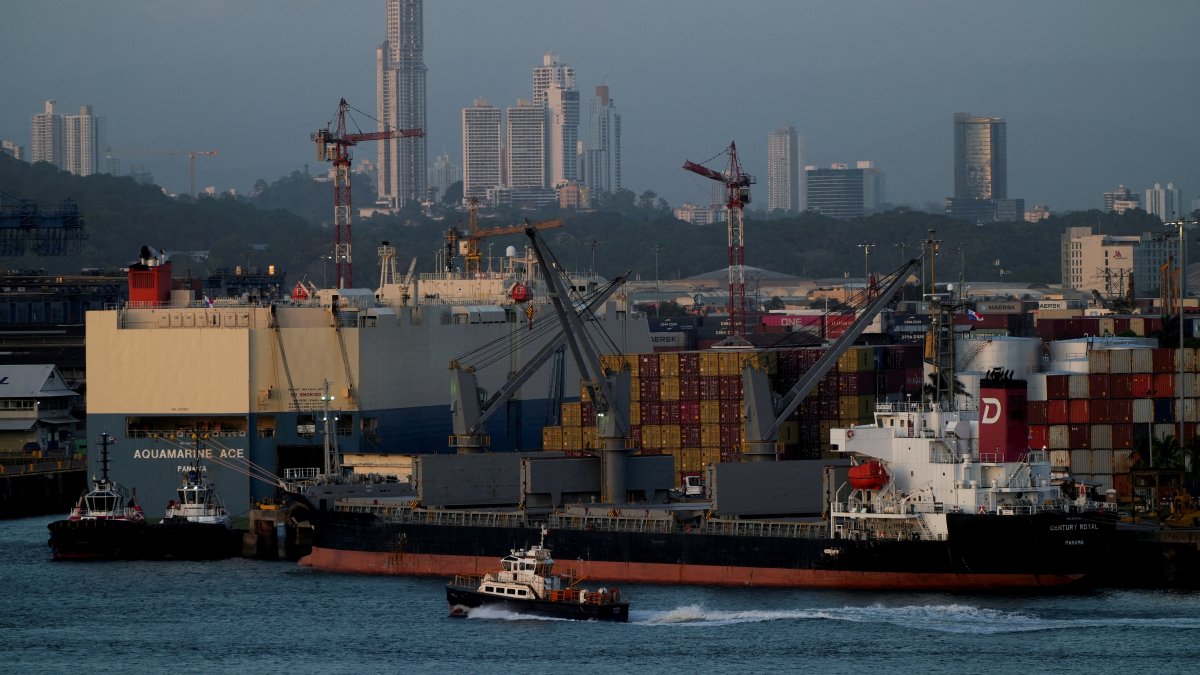 A tugboat sails past the Panama-flagged bulk carrier Century Royal and containers in Panama City, Panama, Jan. 24, 2025. (Reuters Photo)
