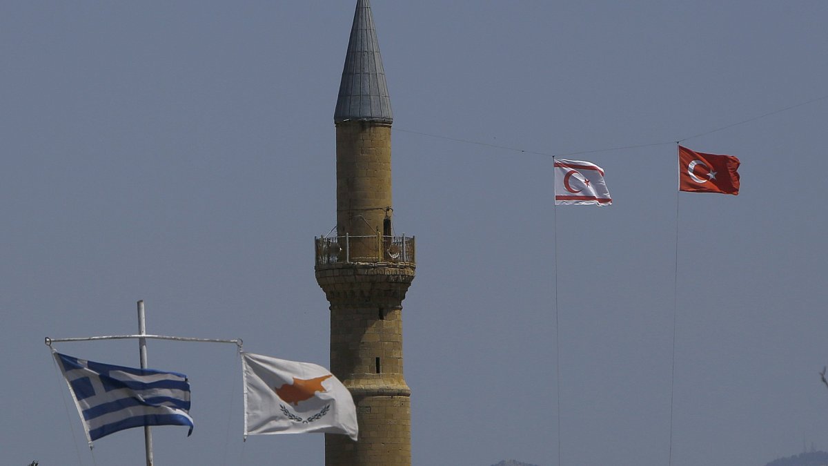 The flags of Turkey and the TRNC flutter by the minaret of the Hagia Sofia with the flags of Greece and Greek Cyprus on poles below, in the divided capital Lefkoşa, TRNC, April 26, 2021. (AP File Photo)
