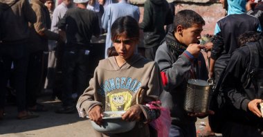 Palestinian children receive aid food being distributed in the Deir al-Balah, Gaza Strip, Palestine, Jan. 16, 2025. (AFP Photo)