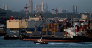 A tugboat sails past the Panama-flagged bulk carrier Century Royal and containers in Panama City, Panama, Jan. 24, 2025. (Reuters Photo)