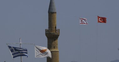 The flags of Turkey and the TRNC flutter by the minaret of the Hagia Sofia with the flags of Greece and Greek Cyprus on poles below, in the divided capital Lefkoşa, TRNC, April 26, 2021. (AP File Photo)