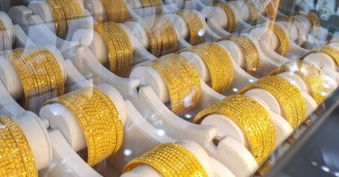 Gold bracelets displayed in a shop window on Green Street, east London, U.K., April 30, 2024. (AFP Photo)