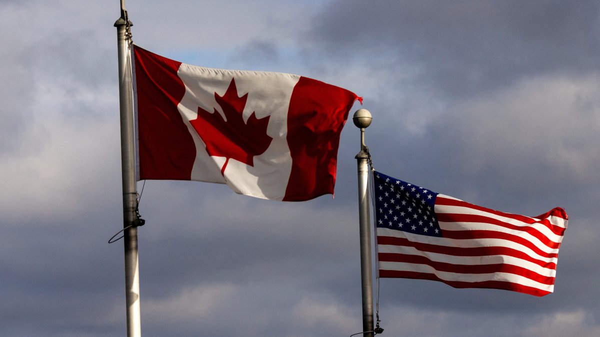 Canadian and U.S. flags wave in the wind near the Detroit River, in Windsor, Ontario, Canada, Feb. 4, 2025. (Reuters Photo)