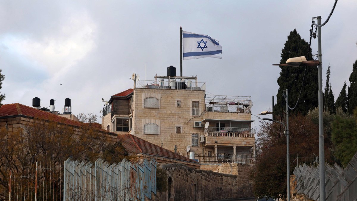 An Israeli flag sways in the wind atop a building over East Jerusalem&#039;s Arab neighborhood of al-Tur, occupied Palestine, Feb. 7, 2025. (AFP Photo)