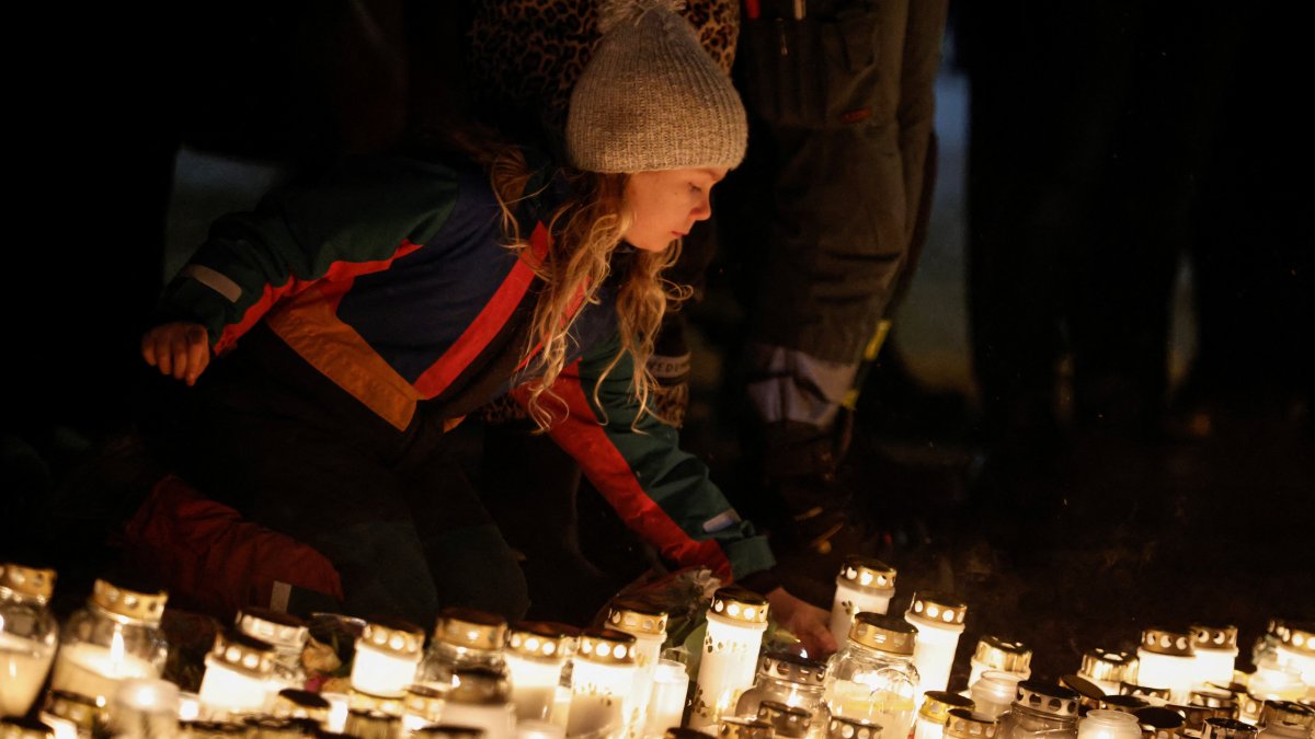A girl lays down a candle near the Risbergska school, following a deadly shooting attack at the adult education center, in Orebro, Sweden, Feb. 7, 2025. (Reuters Photo)