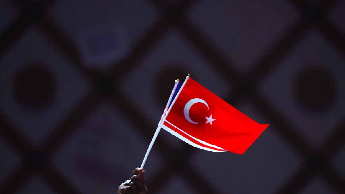 A man holds the Turkish and Malaysian national flags before the arrival of the Turkish president and the Malaysian prime minister for a public lecture event in Putrajaya, Malaysia, Feb. 10, 2025. (EPA Photo)