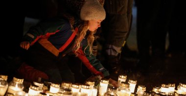 A girl lays down a candle near the Risbergska school, following a deadly shooting attack at the adult education center, in Orebro, Sweden, Feb. 7, 2025. (Reuters Photo)