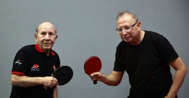 Turkish veteran table tennis players Ahmet Özer and his son Öner Özer pose for a photo at the Macit Özcan Sports Complex, Mersin, Türkiye, Feb. 10, 2025. (AA Photo)
