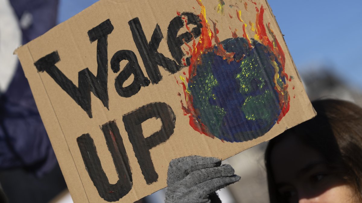 A woman holds a sign as tens of thousands of people march through Amsterdam, Netherlands, Nov. 12, 2023. (AP Photo)